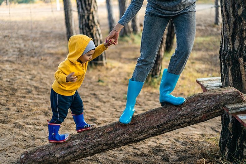 Child walking on a tree trunk