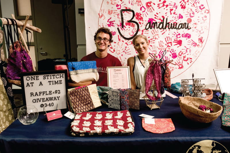 International Business Honors Society students at the 2020 Power Up Women's Leadership Summit displaying handbags made by women in an Indian village visited by the students each year as part of a women's empowerment initiative.