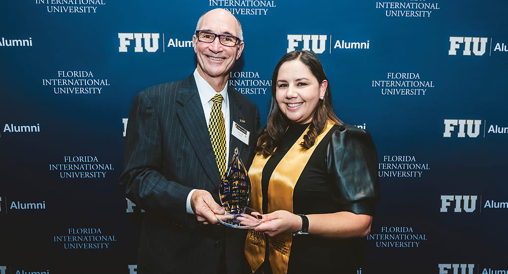 (L to R) FIU President Kenneth Jessell presents Jeanelle Boscan (MBA ’07, BBA ’05), head of human resources, Ocean Bank, with the Charles E. Perry Young Alumni Visionary Award at the Torch Awards program on November 17, 2022.