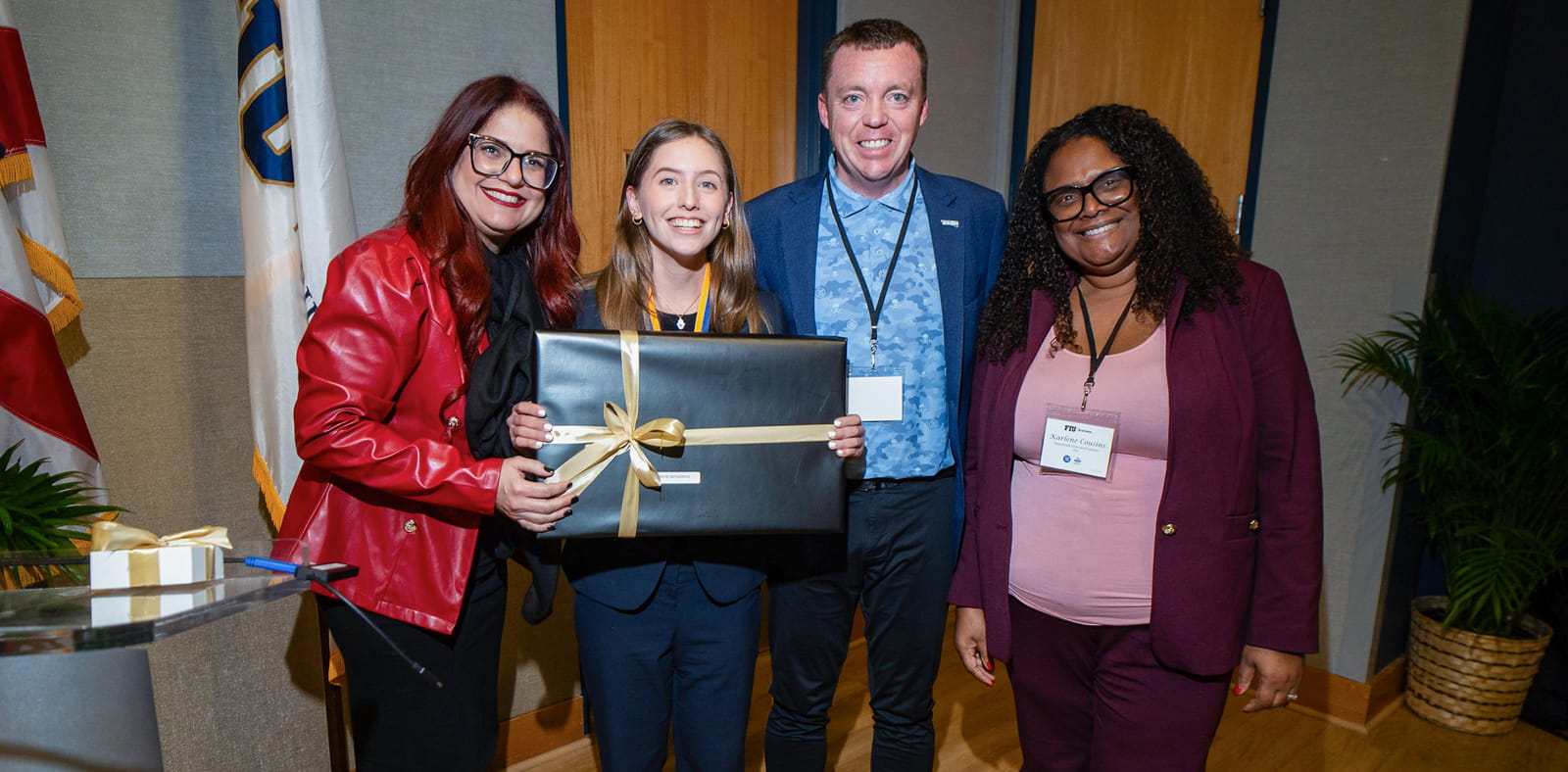 Angelica Bravo (center) celebrates winning the inaugural Best Presenter Award, receiving a new laptop courtesy of event sponsor Tesys Networks