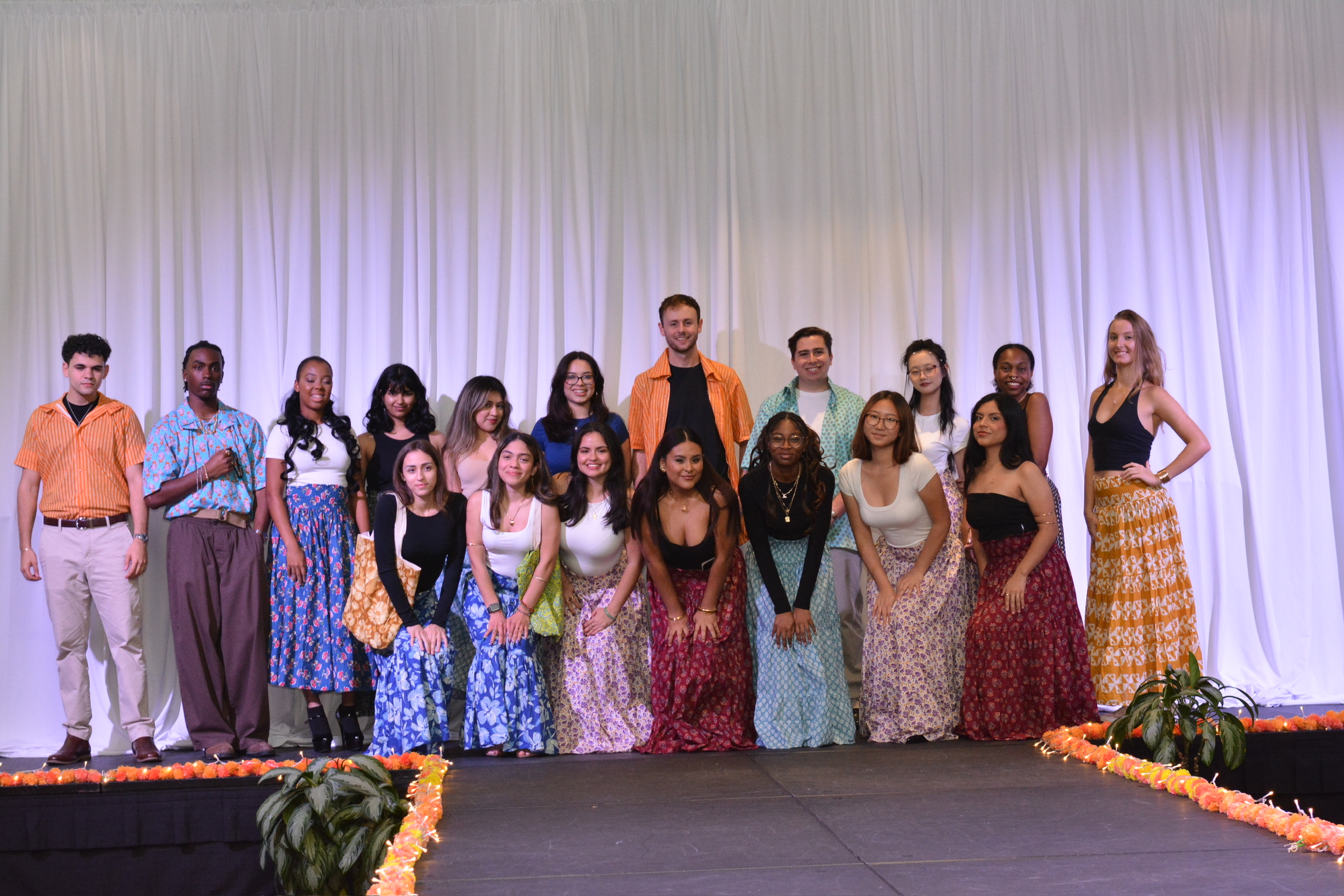 Models in clothing handmade by the Bandhwari artisans pose together on stage at the fashion show